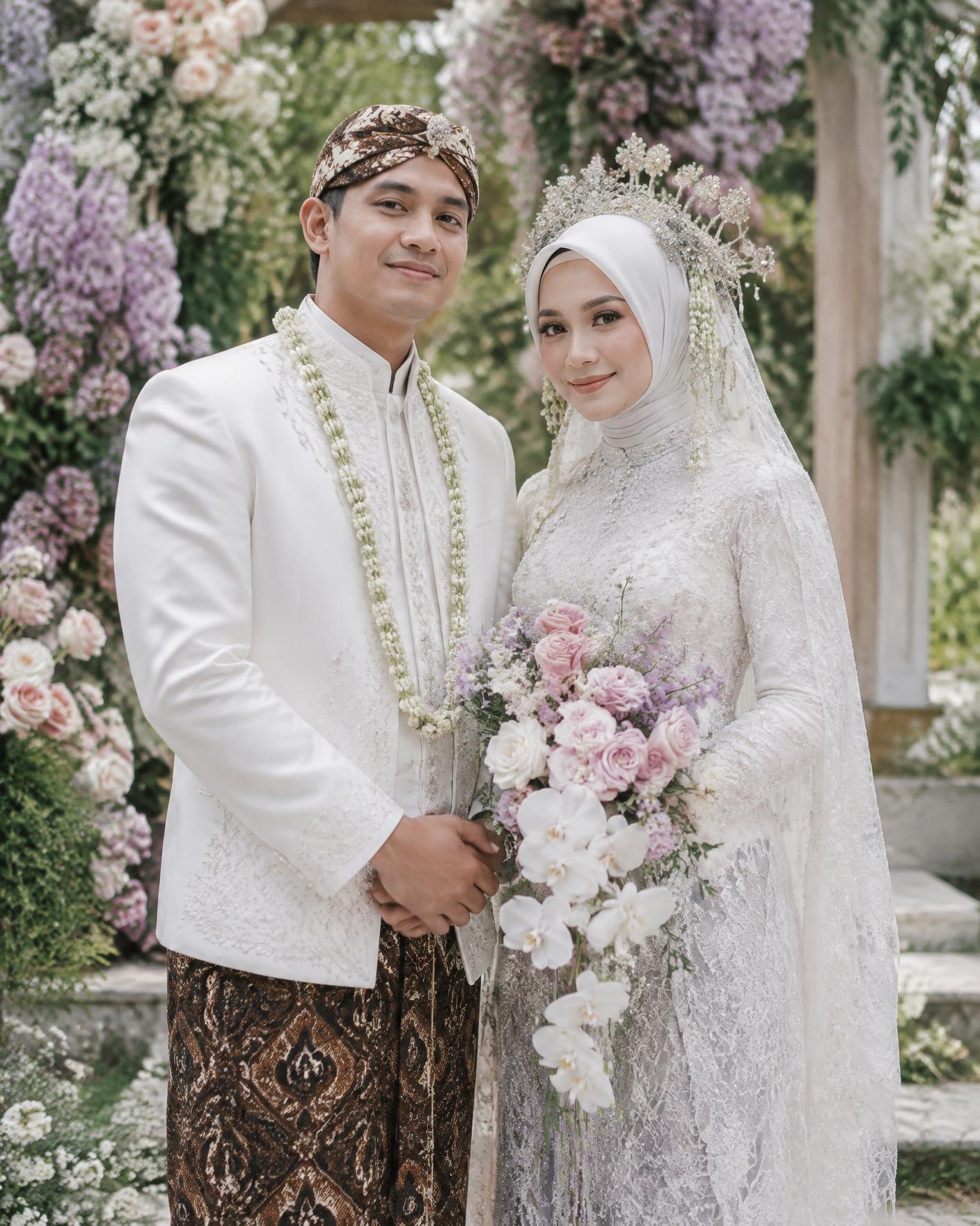 Pasangan pengantin dengan busana tradisional putih
